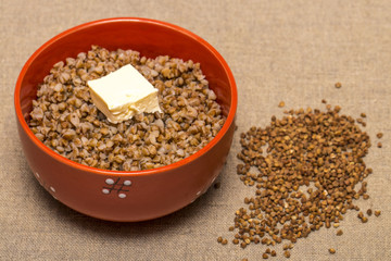 Buckwheat in a red bowl. Healthy food. Buckwheat porridge and bu