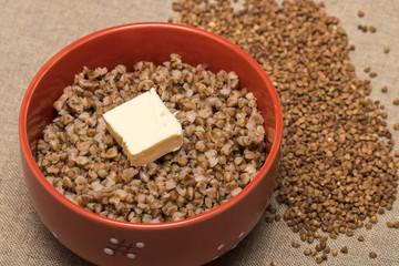 Buckwheat in a red bowl. Healthy food. Buckwheat porridge and bu
