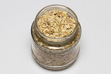 glass jar with rolled oats isolated on white background