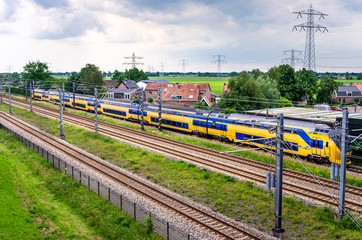 Naklejka premium Railway through the Countryside with a Passing Passenger Electric Train