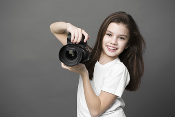 Fototapeta premium Cute brunette little girl holding an photo camera