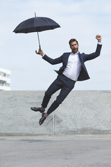 Jump for joy businessman with umbrella