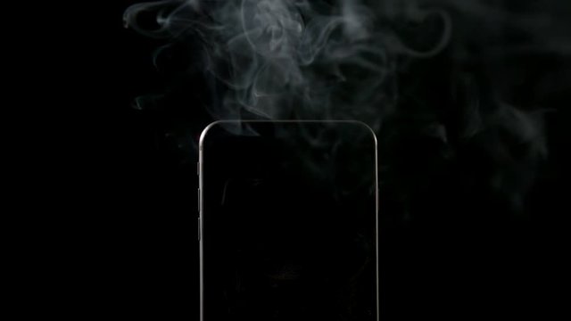 SLOW MOTION: Smoke goes out from smartphone on a black background