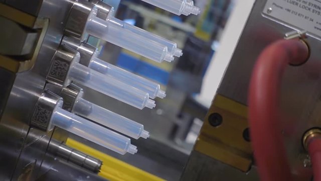 The process of extrusion equipment operation - the movement of different parts - manufacturing disposable plastic products. Slow mo, slow motion, slo mo, high speed camera, 240fps, 250fps