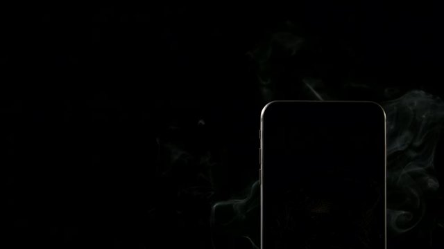 SLOW MOTION: Smoke from smartphone on a dark background - Right