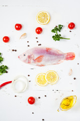 fresh tilapia on white wooden textured background with fresh ros