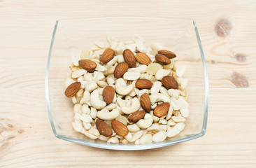 bowl with various nuts on a wooden background