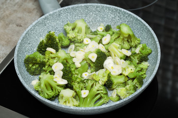 fresh broccoli with garlic in a frying pan
