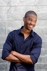 Obraz premium smiling young black man with arms crossed