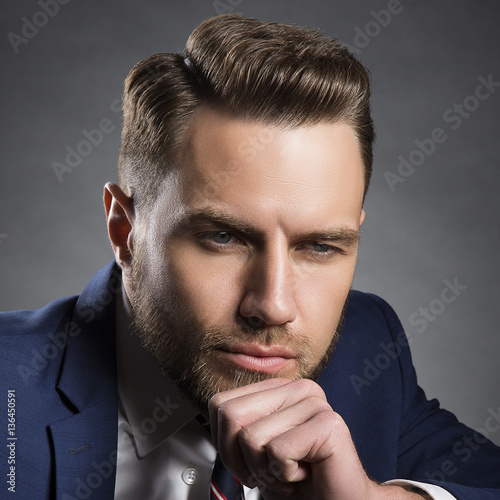 Style hair cut on young brutal man with beard and official