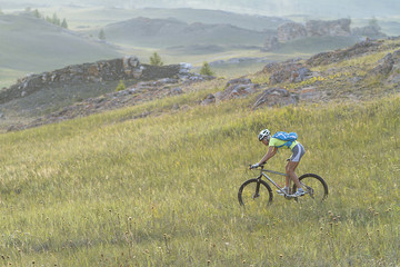 Obraz premium cycling in the mountains, a young girl athlete, mountain biking