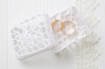 Wedding rings in a white box of lace on the wooden floor