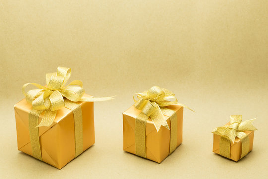 Gold gift box on brown paper background