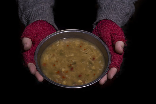 Holding a bowl of soup. Poverty concept