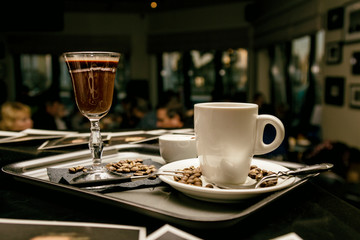 Flatware with coffee glasses and coffee beans in evening cafe. Toned image