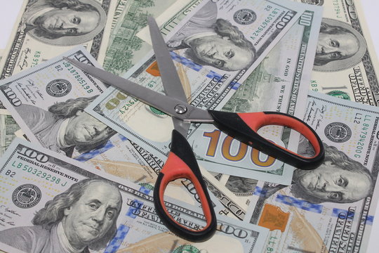 cissors cut money on background