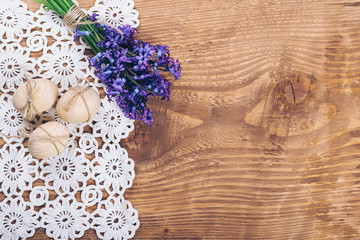 Three wooden easter eggs and spring flowers.