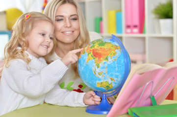 mother with little daughter with globe