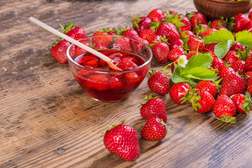 Fresh red strawberry and jam on wood background