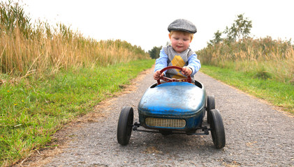 gl&uuml;ckliches Kind mit Tretauto im Fr&uuml;hling