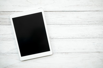 White digital tablet on white wooden table