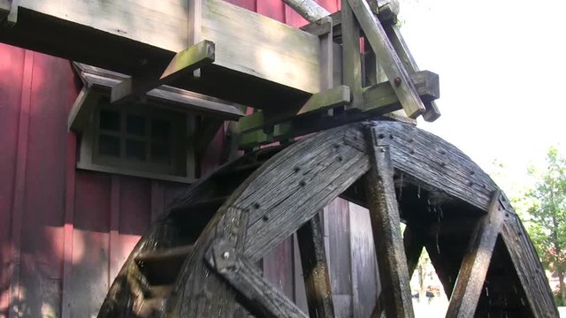 Waterwheel being supplied with a stream of water, making the wheel spin.  This generated electrical or mechanical energy.
