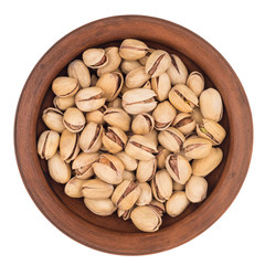 Roasted pistachio nuts in plate, isolated on white background.