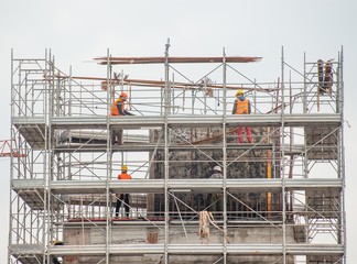 Naklejka premium workers working on scaffolding