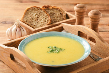 Vegetable cream soup on wooden tray.