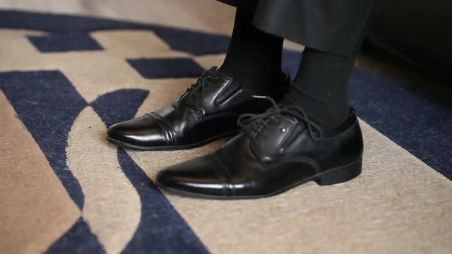 man wears leather shoes. feet close-up
