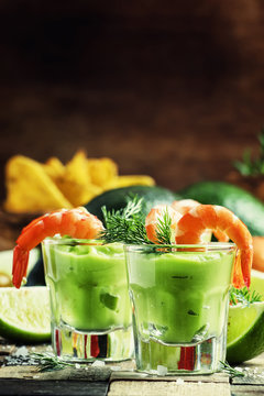 Shrimp cocktail with avocado sauce and lime, vintage wooden back