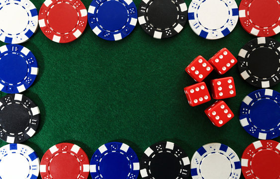 Casino chips and red dice on green background
