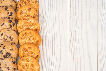 Biscuits with chocolate and peanut on old wooden table.