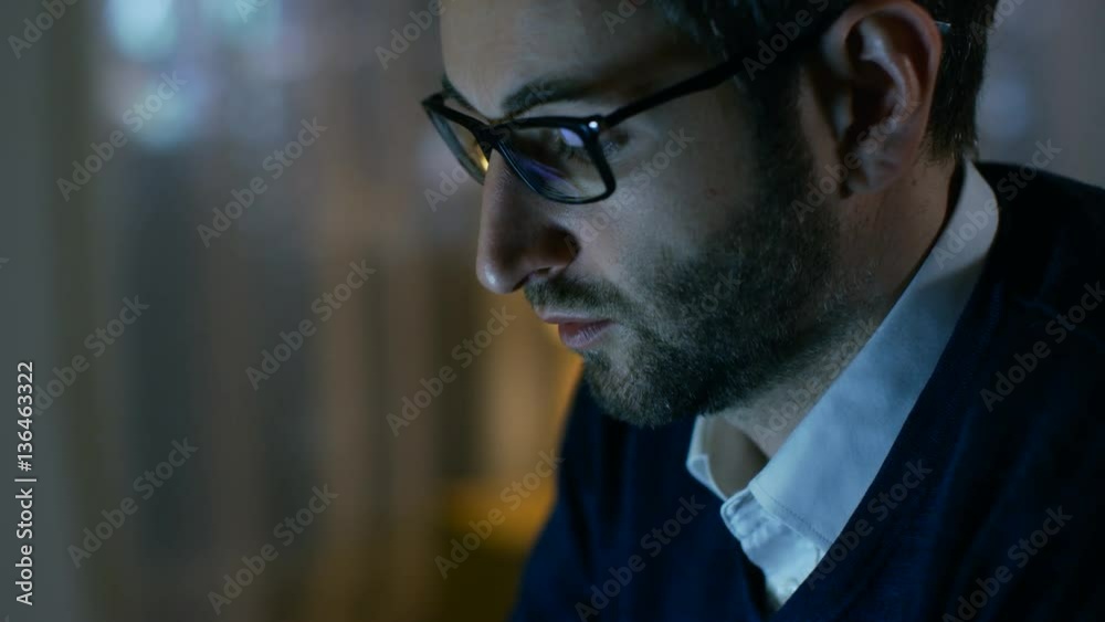 Aufkleber close-up of a man at home working on a computer. he wears glasses, screen reflects in them. shot on 