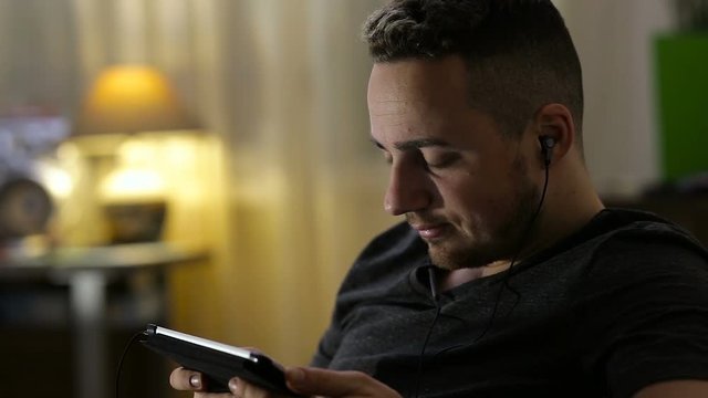 Man watching video or listening music on tablet at home