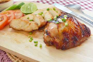 Roast Chicken with tomatoes, cucumbers, lemon and spicy sauce dip on a cutting board