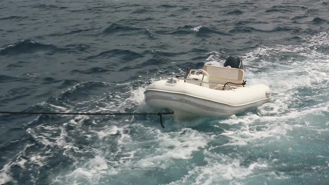Inflatable empty boat tied to the yacht