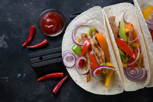 Mexican pork fajitas served in wheat wraps, above view