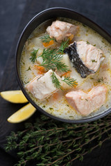 Fish soup with salmon in a ceramic bowl, close-up, above view