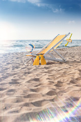 Obraz na płótnie Canvas Sunchair at the Beach and a big Lensflare