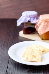 Crackers on a plate on wooden background.