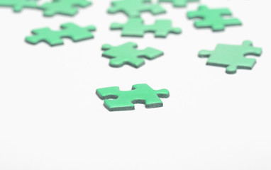 Green puzzle pieces on a white surface.