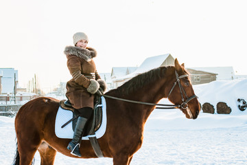 Woman in brown dress and brown horse in a winter