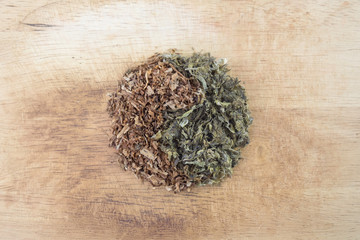Fototapeta na wymiar Marijuana / Marijuana and tobacco on wood background, shaped Yin Yang.