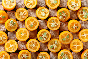 slices of kumquat with pieces of brown sugar, top view