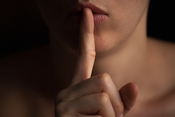 Fototapeta premium young beautiful girl holding a finger to her mouth