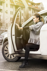 Young business woman casually dressed getting out of her car. Woman parking her car and getting out.