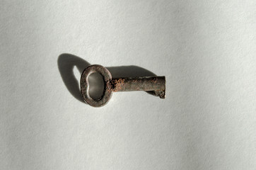 Horizontal View of a Corroded Small Skeleton Key with shadow on