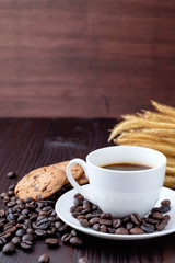 Coffee cup and coffee beans on wooden background