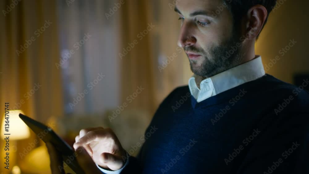 Aufkleber close-up of a respectable middle aged man using tablet computer. in the background his apartment don